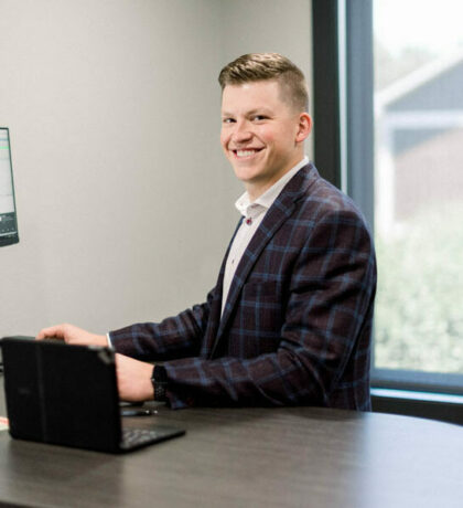 Man standing at a desk with his laptop